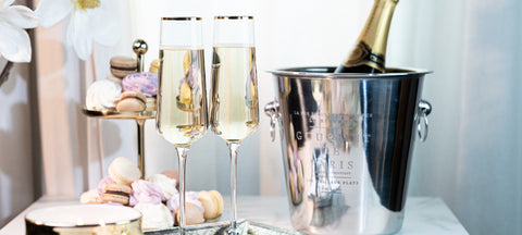Two champagne flutes and an ice bucket with macarons, an anniversary toast
